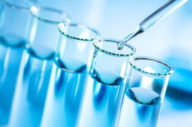 Bir damlatıcı ve test tüpleri, biyoteknoloji ve tıbbi bilimsel araştırmalarla laboratuvar vitrinleri.