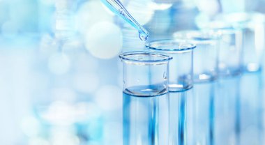 Bir damlatıcı ve test tüpleri, biyoteknoloji ve tıbbi bilimsel araştırmalarla laboratuvar vitrinleri.