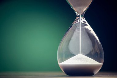 Kum saati iş bitimi, aciliyet ve zaman tükenmesi için yeşil arka plan kavramını geçirir