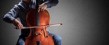 Kopya alanı ile izole edilmiş bir orkestra arka planında çalan çello çalar veya çellocu