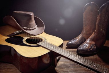 Country müzik festivali akustik gitar, kovboy şapkası ve bot arka planıyla canlı konser