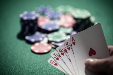 Kumarhanede poker oynamak, kumarda, bahislerde ve kazanmada kraliyet floş kart konseptini kazanmak.