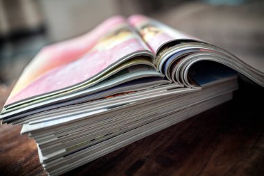 Arka plandaki masa ucunda dergi, broşür veya katalog