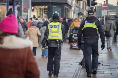 İngiltere 'deki bir etkinlikte ceketli polis kalabalığı kontrol ediyor