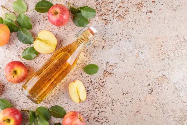 발효된 과일의 식초는 베이지 콘크리트 배경에 신선하게 사과가 유리병에 넣는다 — 스톡 사진
