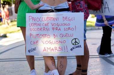 Manduria, İtalya - 13 Temmuz 2022. İtalyanca yazıtları olan bir kızın bacakları: Erkeklerin sevişmesi hakkında değil, savaşması hakkında endişelen.