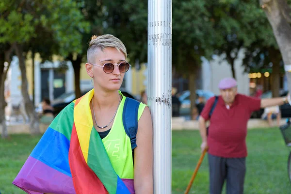 Manduria Italy 2022年7月13日南イタリアの通りでゲイのプライドパレード中に列の横に立って虹の旗のLgbtqを身に着けている若い美しいレズビアンの女の子 クローズアップ 選択的フォーカス — ストック写真