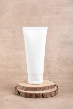 White squeeze bottle plastic tube mockup for medicine or cosmetics on wooden podium on beige background. Skin care product, body lotion, facial cream, gel or mask, Natural organic beauty cosmetics