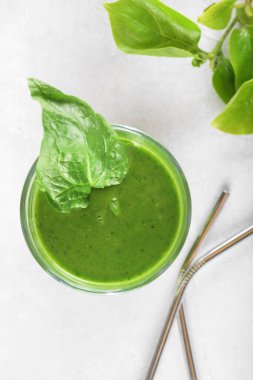 Bardakta ıspanaklı, muzlu ve vejetaryen sütlü sağlıklı yeşil smoothie ve taze malzemeler. Detoks, diyet, sağlıklı, vejetaryen gıda konsepti, üst görünüm