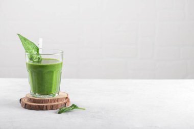 Açık gri arka planda ıspanaklı, muzlu ve vejetaryen sütlü sağlıklı yeşil smoothie. Detoks, diyet, sağlıklı, vejetaryen gıda konsepti, kopyalama alanı, minimalizm