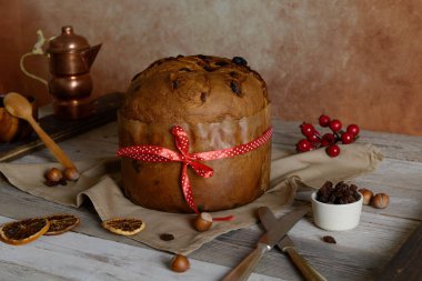 Traditional Italian Christmas Cake Panettone with red bow on wooden rustic background. Homemade artisan sourdough panettone ready for eating. Classic italian Christmas Food and Edible gift clipart