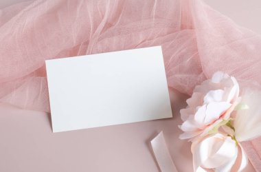 Pembe arka planda açık renkli pembe kumaş üzerinde beyaz, boş kart modelleme şablonu, düğün davetiyesi için tasarım elemanı, teşekkür kartı, tebrik kartı veya davetiye kartı. Kırtasiye modeli