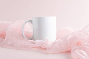 Pembe arka planda pembe kumaş üzerine beyaz kupa modeli, kopyalama alanı. Tasarım, markalaşma ve iş için boş şablon
