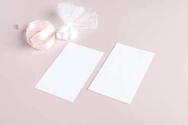 Pastel pembe arka planda iki adet boş düğün davetiyesi kırtasiye kartı, kadınsı blog. Sevgililer günü kartı, sevgililer günü geçmişi, anneler günü. Minimalist modelleme oranı 5x7