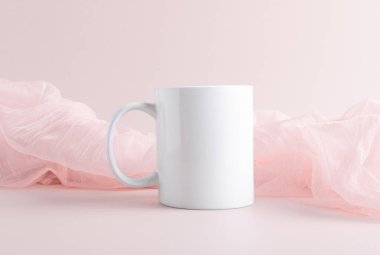 Reklam mesajı için boş kopya alanı olan beyaz kupa modeli ya da pastel pembe arka planda promosyon içeriği. Kahve fincanı 11 ons maket, kapatın.