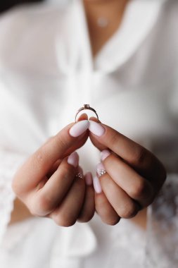 Gelin elinde bir alyans tutuyor.