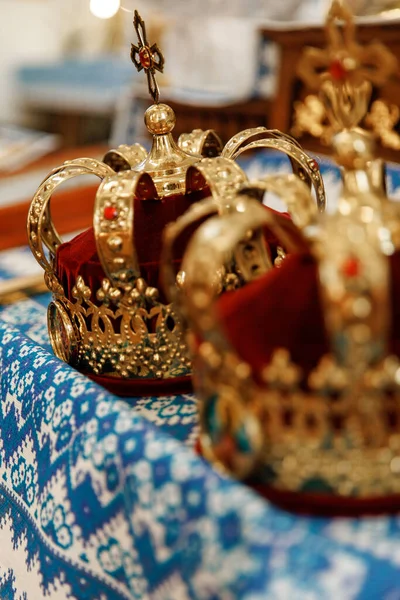 Rahip düğün töreni için hazırlanıyor. Altın taçlar, İncil ve nikah masasında mihrapta alyans. Geleneksel dini düğün