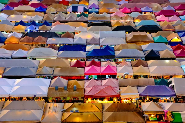 Colorful market tents at sunset. Fairs and marketplaces, small businesses, food stalls, shopping and dining outdoors, Asian markets, local traditions, tourist traps or attractions. Ratchada Rot Fai