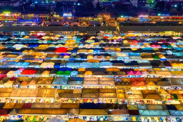 View of rows of colorful outdoor market tents and food stalls at night. Fairs, marketplaces, shopping and dining outdoors, Asian markets, local traditions, tourist traps or attractions. Ratchada Rot