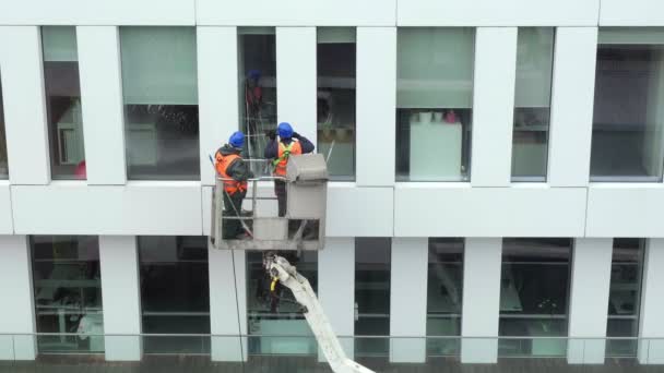 Twee Arbeiders Een Veiligheidsharnas Wassen Muren Panelen Ramen Van Kantoorgebouw — Stockvideo