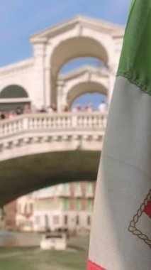 İtalyan deniz bayrağı vaporetto sırasında sallanıyor ya da İtalya, Venedik, İtalya 'da Grand Canal' da su otobüsü gezintisi. Arka planda Rialto Köprüsü veya Ponte di Rialto, seçici odak noktası, ünlü turistik cazibe. 4k