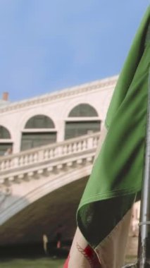 İtalyan deniz bayrağı vaporetto sırasında sallanıyor ya da İtalya, Venedik, İtalya 'da Grand Canal' da su otobüsü gezintisi. Arka planda Rialto Köprüsü veya Ponte di Rialto, seçici odak noktası, ünlü turistik cazibe. 4k