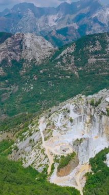 Apuan Alps, Carrara, İtalya 'daki mermer ocağının yavaş hava görüntüsü. Güneşli bir günde panoramik drone görüntüsü, ünlü beyaz Carrara mermeri Antik Roma 'dan beri kazılmış, birçok başyapıt için kullanılmış,