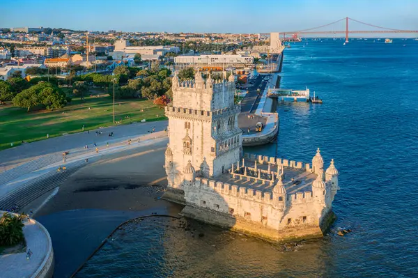 stock image Drone close view of Belem tower and Tagus riverbank, Lisbon, Portugal at blue sky at sunset. Medieval fortification in late Gothic or Manueline style, UNESCO world heritage site, Age of Discoveries