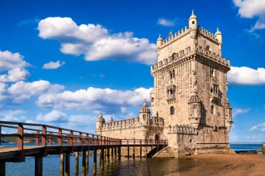 Belem kulesi ve ahşap köprü, Lizbon, Portekiz mavi yaz günü gökyüzü bulutlu. Tagus Nehri 'ndeki ortaçağ kalesi Gotik veya Manueline tarzı, UNESCO dünya mirası alanı, Keşifler Çağı