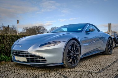 Lizbon, Portekiz - 20 Ocak 2024: Lüks Aston Martin Vantage 2023 üstü açık araç kaldırım taşı yolda park edilmiş, mavi gövdeli, benzersiz spor araba. 