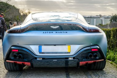 Lizbon, Portekiz - 20 Ocak 2024: Lüks Aston Martin Vantage V8 2018 aracının arka manzarası kaldırım taşı yolda park edilmiş, mavi gövdeli, benzersiz spor arabası