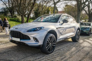 Lizbon, Portekiz - 20 Ocak 2024: Lüks Aston Martin DBX arazi aracı kaldırım taşı yolda park edilmiş, gümüş gövdeli, benzersiz spor araba. 
