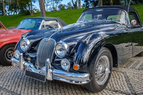 Lizbon, Portekiz - 20 Ocak 2024: Klasik koyu yeşil Jaguar XK150 damperli coupe araba kaldırım yolunda park edilmiş. İki koltuklu araç, spor araba, üstü açılır araba.