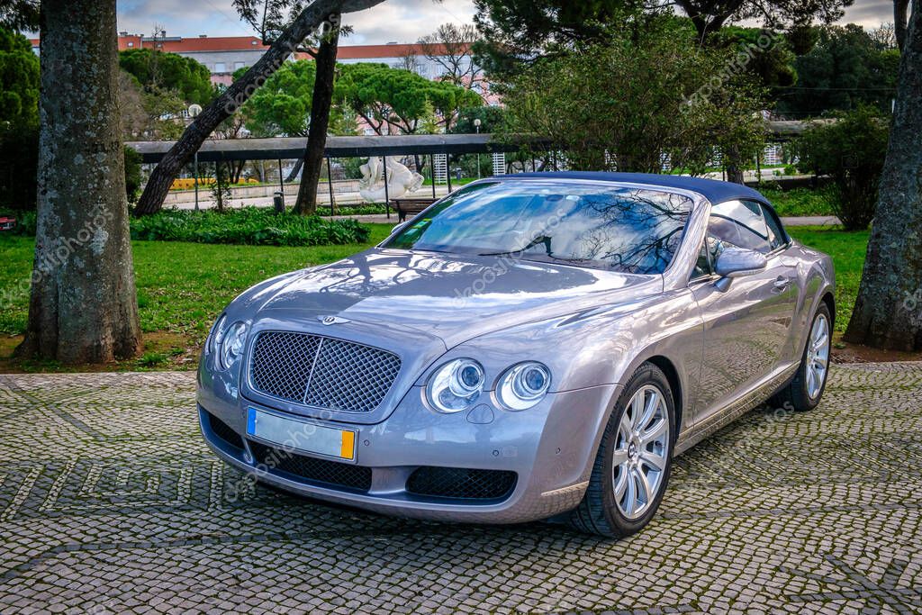 Lisbon, Portugal - Jan 20, 2024: Elegant Bentley Continental GT coupe parked on a historic street with trees in the background