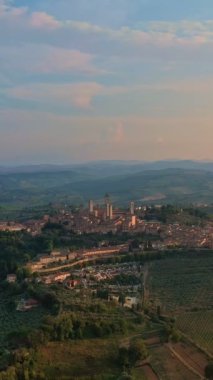 Hava desteği, San Gimignano 'nun ünlü kulelerinin, Toskana bölgesinin şafak vakti Toskana tepelerinin, bir UNESCO miras alanı olan ortaçağ İtalyan gökdelenlerinin geniş insansız hava aracı görüntüsünü ortaya çıkarıyor. Alçak güneş