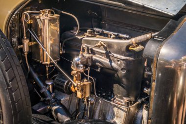 Lizbon, Portekiz - Sep 29, 2024: Güneşli bir günde 1923 model Minerva 20HP torpido otomobilinin yakın görüntüsü, eski tip motor parçaları ve ince işçilik, karbüratörler ve cilalanmış cilalı