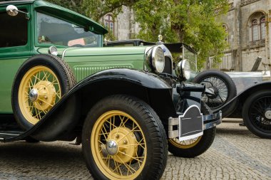 Lizbon, Portekiz - 15 Ekim 2023: Ford Model A 'nın ya da A-Model Ford' un ya da A-Model A-bone 'un orijinal yeşil renginde parke taşı yolda diğer eski arabaların yanında yıllık klasik araba sahipleri tarafından park edilmiş ön görüntüsü