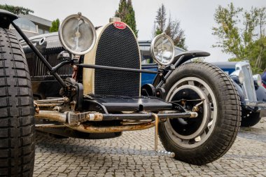Lizbon, Portekiz - 15 Ekim 2023: kaldırım taşı yolundaki efsanevi Pur Sang Bugatti Tipi 35 'in ön görüntüsü. Yarış arabası sınıfı, 1920 'lerin Grand Prix ikonu, Bugatti, Fransa. Büyük farlar, radyatör ızgarası.