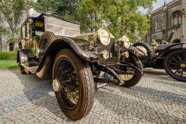 Lizbon, Portekiz - 15 Ekim 2023: 1920 model lüks Rolls-Royce Silver Ghost damperli arabası güneşli bir günde tarihi binanın yakınına park edilmiş. 1920 'lerde Rolls-Royce Ltd.' nin 4 kapılı turnuva arabası.