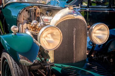 Lizbon, Portekiz - Sep 29, 2024: Bentley 4 koltuklu ön bölümü seçici odaklı. Eski büyük farlar, radyatör ızgarası ve açık kaputlu klasik motor, bileşenleri.