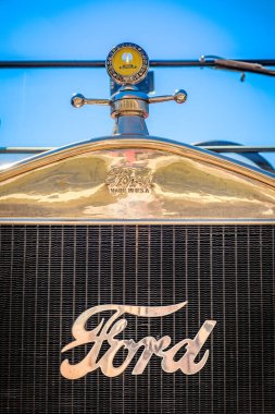 Lisbon, Portugal - Sep 29, 2024: Front view of Ford car radiator grille and Boyce MotoMeter on hood top or bonnet and shiny Ford emblem and logo plate on grille. Embossed lettering of Ford and Made in clipart