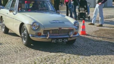 Lizbon, Portekiz - 20 Ocak 2024: Güneşli bir günde İngiliz araba sahipleri kulübü toplantısı sırasında arabalar yavaş yavaş geçiyor. İnsanlar MG, Jaguar, Oxford, Morris 'in modern ve klasik araba geçit töreninden hoşlanıyorlar.