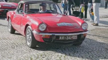 Lizbon, Portekiz - 20 Ocak 2024: Güneşli bir günde İngiliz araba sahipleri kulübü toplantısı sırasında arabalar yavaş yavaş geçiyor. İnsanlar Triumph, Jaguar, MG, Range 'den modern ve klasik araba geçit törenini seviyorlar.