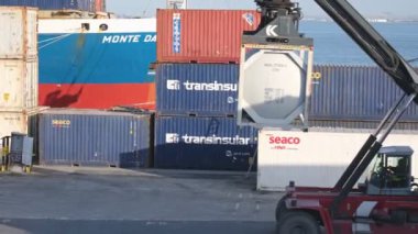 Mar 13, 2024 - Lizbon, Portekiz: Güneşli bir günde ticari liman terminalindeki yayıcı yakıt tankı konteynırının yakın görüntüsü ve izleme görüntüsü. İş, lojistik, ithalat, ihracat
