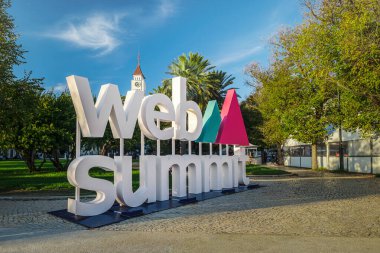 6 Kasım 2024 - Lizbon, Portekiz: Güneşli açık mavi gökyüzünde, yemyeşil palmiye ağaçları ile parkın dışında sergilenen büyük Web Zirvesi tabelası. Büyük teknoloji konferansı, internet teknolojisi, ortaya çıkan teknoloji