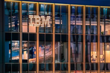 15 Ocak 2025 - Lizbon, Portekiz: IBM ofis binasının parıldayan logosu ve parlak cam dış görünüşlü gece görüşü. Aydınlatılmış iç mekanlar ve yansımalar, yenilikçi ruh ve küresel varlık