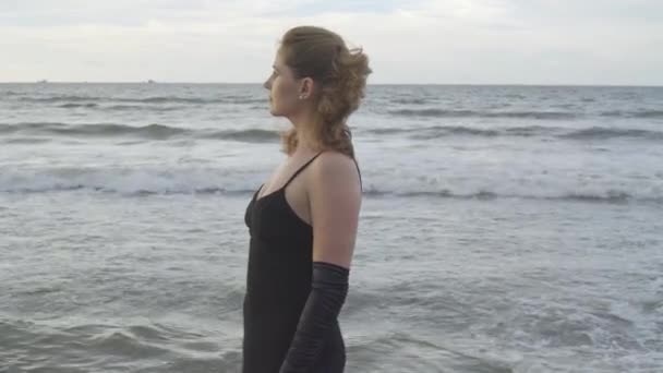 Model Dlouhých Černých Šatech Molu Přímořském Pózuje Nad Zamračenou Oblohou — Stock video
