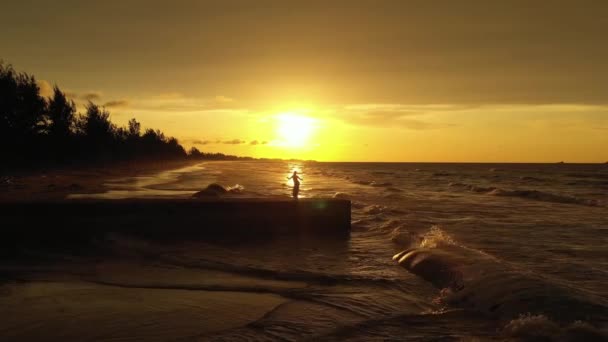 Gün Batımında Iskelede Elleri Havada Siyah Eşarp Tutan Zarif Genç — Stok video