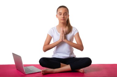 İç güç. Genç bir kadın nilüfer çiçeği pozunda oturuyor ve avuçlarını yoga minderinde dizüstü bilgisayarla göğüs bölgesinde birleştiriyor, beyaz arka planda izole edilmiş..