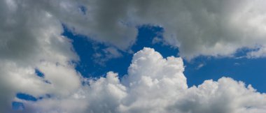 Mavi gökyüzüne karşı beyaz kümülüs bulutları. Yazın kırsal alan. Web pankartı.